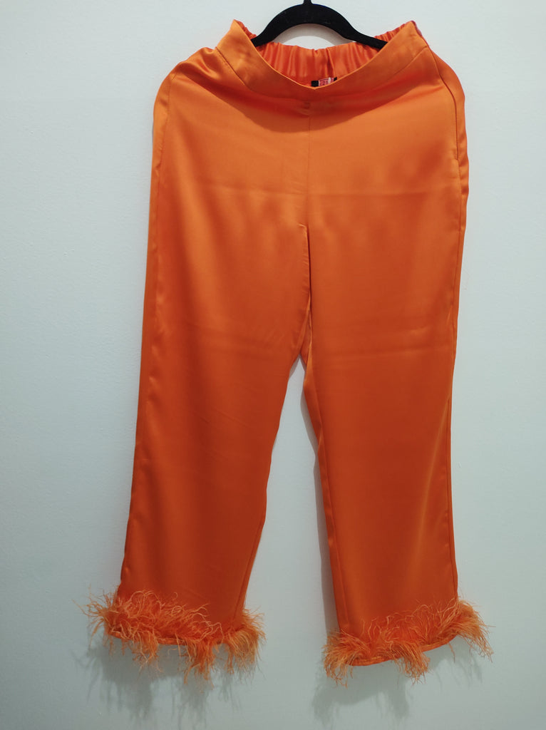 Pantalón de satín anaranjado con plumas
